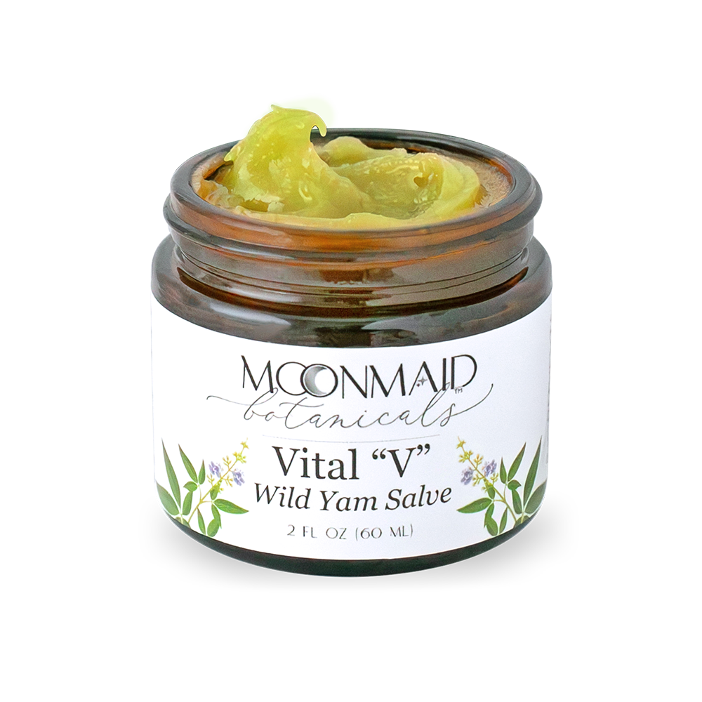 An open jar of Moonmaid Botanicals Vital V Wild Yam Salve showing the rich, translucent green-gold herbal ointment texture.