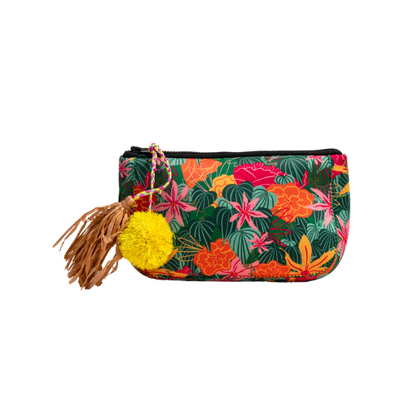 Anna's mini toiletry bag featuring a green tropical floral pattern with a decorative yellow pom-pom and brown leather tassel.