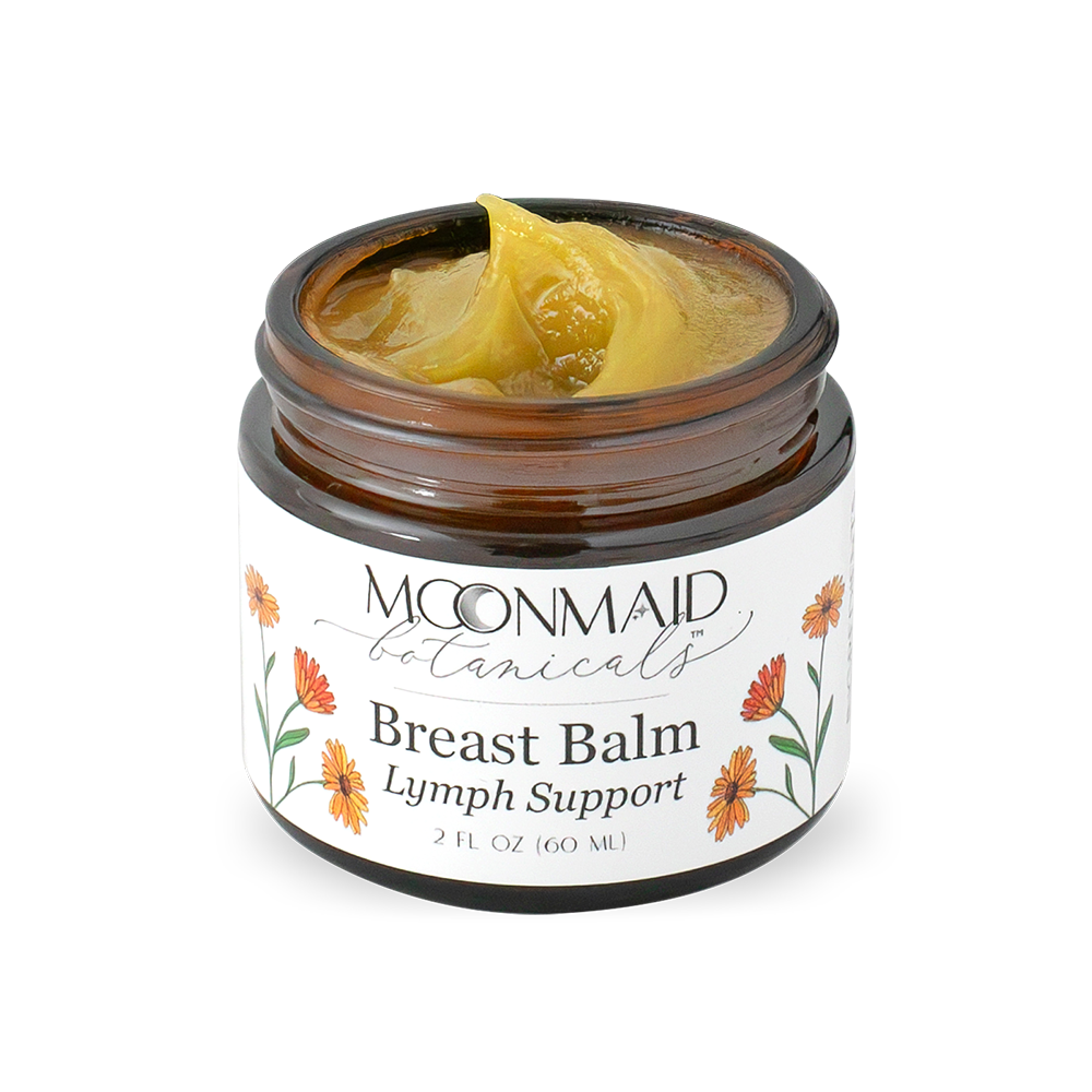 An open jar of Moonmaid Botanicals Breast Balm showing a smooth, golden-yellow swirled herbal salve texture optimized for lymph support.