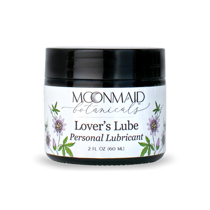 A 2 fl oz amber glass jar with a glossy black lid featuring MoonMaid Botanicals Lover's Lube Personal Lubricant against a solid dark background.